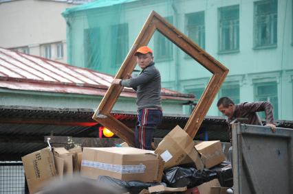 Москва. Гастарбайтеры сгружают мусор в контейнер.