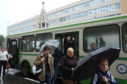 Проливной дождь в Москве. Пассажиры выходят из автобуса.