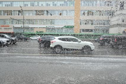 Проливной дождь в Москве. Машины едут по дороге.