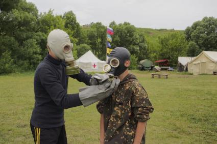 Тульская область. Занятия в военно-патриотическом лагере `Куликово-поле`. Дети примеряют противогазы.