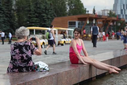 Москва. Девушка фотографируется у фонтана в Парке Победы.