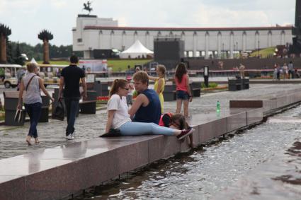 Москва. Люди сидят у фонтана в Парке Победы.