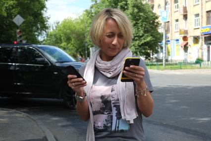 Москва. Девушка с телефонами в руках.