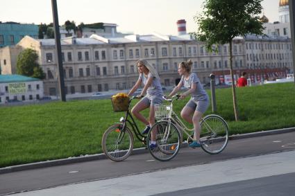 Москва. Девушки катаются на велосипедах в парке искусств `Музеон`.
