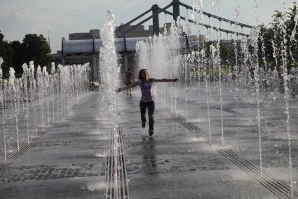 Москва. Девушка бежит по фонтану в парке искусств `Музеон`.