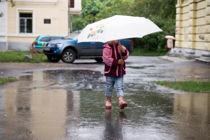 Маленький ребенок под зонтиком во время прогулки