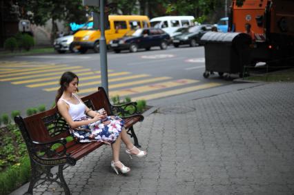 Армения, Ереван. Девушка сидит на лавочке.