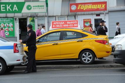 Москва. Припаркованная на тротуаре машина такси.