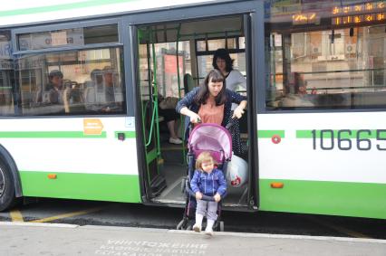 Москва. Женщина с ребенком в детской коляске падает на выходе из автобуса.