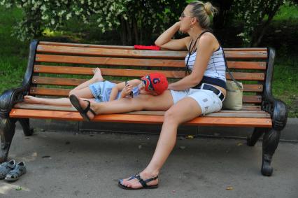 Жара в Москве. Женщина с ребенком отдыхают на лавочке в Парке Горького.