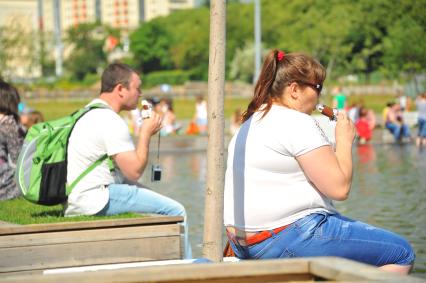 Жара в Москве.  Мужчина и женщина едят мороженое в Парке Горького.