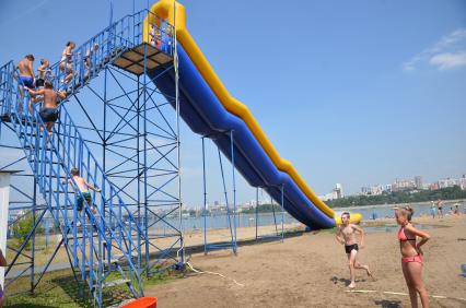 Новосибирск. Люди катаются с водяной горки на городском пляже.