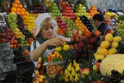 Москва. Продавщица раскладывает фрукты на Дорогомиловском рынке.