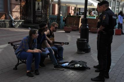 Москва. На Старом Арбате прошла акция протеста уличных музыкантов.
Молодой человек играет на гитаре в знак несогласия с действиями полиции.