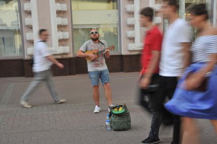 Москва. На Старом Арбате прошла акция протеста уличных музыкантов.
Молодой человек играет на гитаре в знак несогласия с действиями полиции.