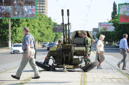 Украина. Луганск. Ополченцы рядом с зенитным орудием на улице города.