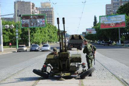 Украина. Луганск. Ополченцы рядом с зенитным орудием на улице города.