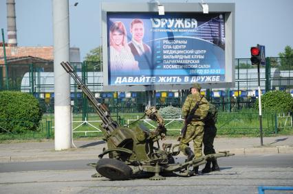 Украина. Луганск. Ополченцы рядом с зенитным орудием на улице города.