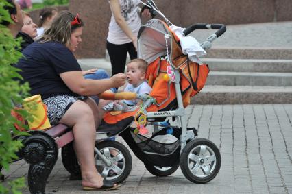 Москва. Женщина кормит ребенка на улице.