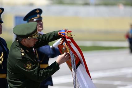 Краснодарский край, пос. Раевский. Министр обороны РФ генерал армии Сергей Шойгу прикрепляет орден Суворова на знамя 7-й гвардейской Краснознаменной десантно-штурмовой (горной) дивизии.