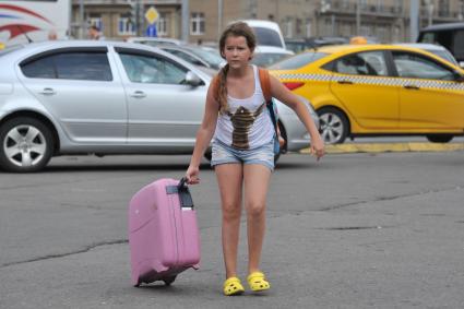 Москва. Девочка с чемоданом на площади Белорусского вокзала.