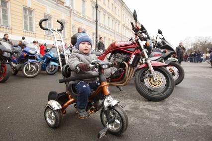Санкт-Петербург. Мальчик на детском велосипеде на Дворцовой площади во время открытия мотосезона.