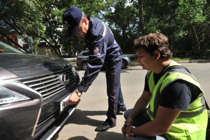 Москва. Контролер `Московского паркинга` снимает лист бумаги, закрывающий номер автомобиля.