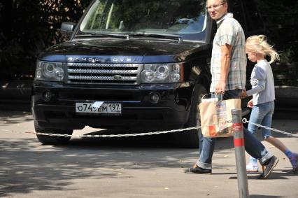 Москва. Припаркованный автомобиль с листом бумаги, закрывающим номерной знак.