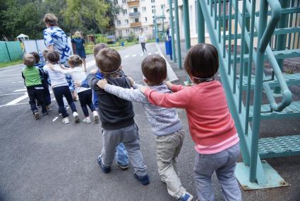 Воспитатель выводит детей в ватно-марлевых повязках, во время учебной эвакуации из детсого сада при пожаре. Екатеринбург