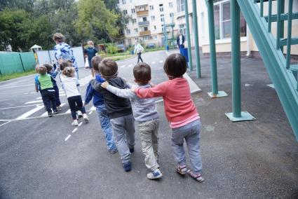 Воспитатель выводит детей в ватно-марлевых повязках, во время учебной эвакуации из детсого сада при пожаре. Екатеринбург