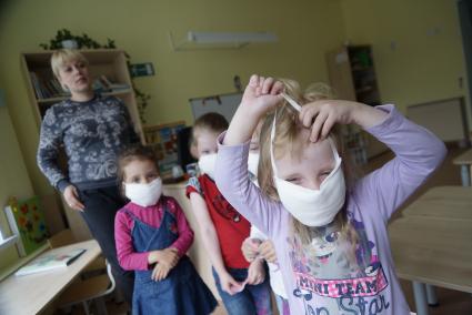 Ребенок одевает ватно-марлевую повязку, во время учебной эвакуации из детсого сада при пожаре. Екатеринбург