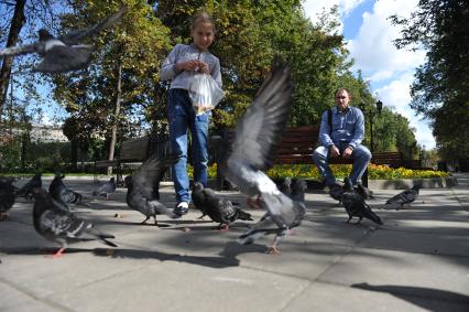 Москва. Девочка кормит голубей в сквере Девичьего поля.