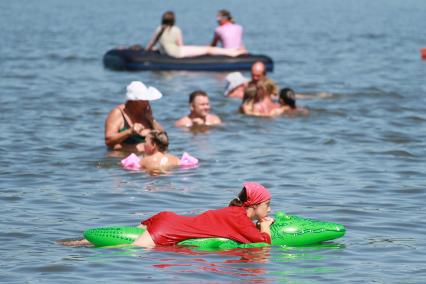 Барнаул. Девушка в футболке плавает на надувном крокодиле.