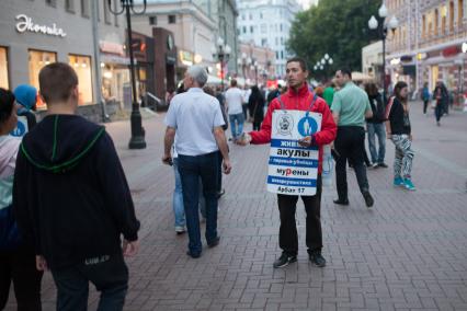 Москва. Промоутер раздает флаеры прохожим на Старом Арбате.