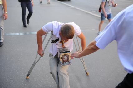 Москва. Мужчина подает деньги инвалиду.