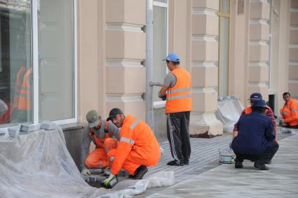 Москва. Рабочие укладывают тротуарную плитку в ходе ремонтных работ по благоустройству Мясницкой улицы.