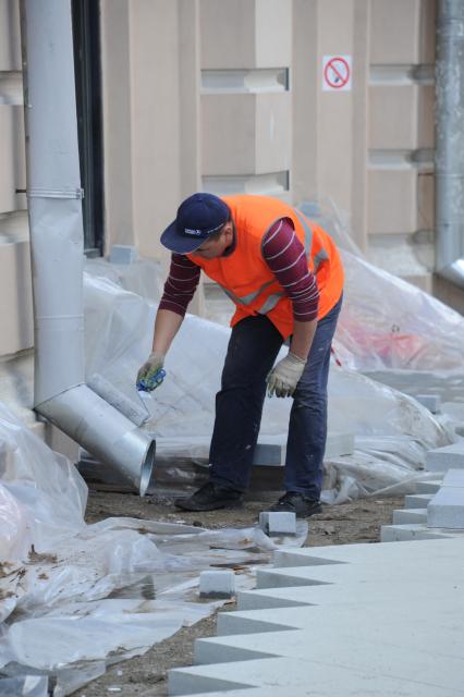 Москва. Рабочий красит водосточную на фасаде здания в ходе ремонтных работ по благоустройству Мясницкой улицы.