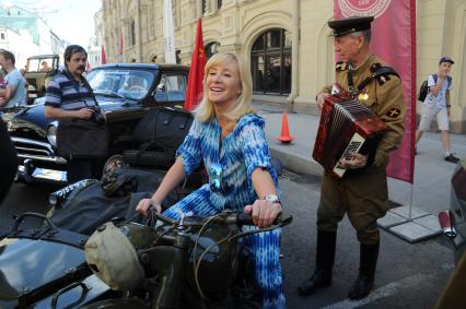 Москва. Телеведущая Оксана Пушкина на старте `ГУМ-Авторалли-2015` с участием ретро-автомобилей в Ветошном переулке.