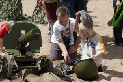 Самара. Дети рассматривают оружие времен Великой Отечественной войны во время проведения военно-исторической реконструкций `Пинский десант`.