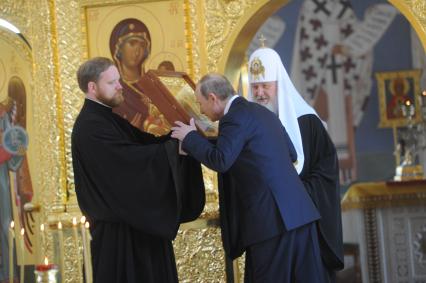 Москва. Президент РФ Владимир Путин (в центре) и патриарх Московский и всея Руси Кирилл (справа) во время посещения отреставрированного храма Святого Равноапостольного Князя Владимира при Московском епархиальном доме.