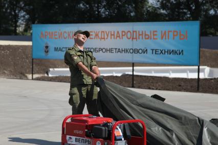 Воронежская область, г. Острогожск. Военнослужащий снимает тент с генератора во время проведения всероссийского этапа конкурса `Мастера автобронетанковой техники`, проходящего в рамках `Армейских международных игр-2015`.