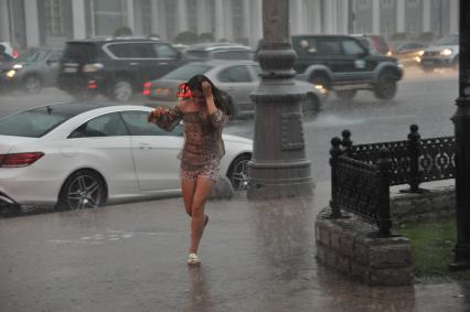 Ливень в Москве. Промокшая девушка бежит по улице.