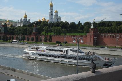 Москва. Яхта-ресторанов Radisson Royal Moscow плывет по Москва-реке мимо Кремлевской набережной.