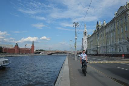 Москва. Велосипедист едет по Софийской набережной.