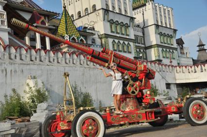 Москва. Девушки фотографируются у зенитной пушки, расписанной в хохломском стиле на территории Измайловского Кремля.