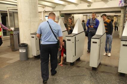 Москва. Контролер московского метрополитена у турникетов на станции `Пушкинская`.