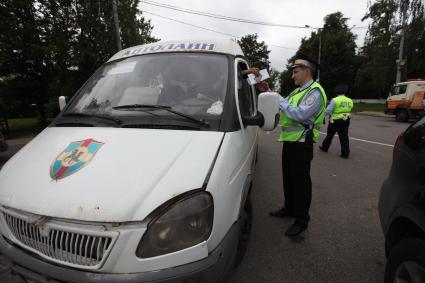 Москва. Сотрудник ДПС проверяет документы у водителя маршрутного такси в ходе рейда по контролю за частными перевозчиками.