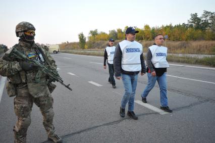 Донецкая область. Украинский военнослужащий и представители ОБСЕ  во время процедуры обмена военнопленными, в результате которой были освобождены 60 ополченцев ДНР и 30 украинских военнослужащих.