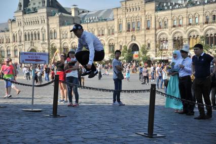 Москва. Один из гостей киргизской свадьбы прыгает на Красной площади.