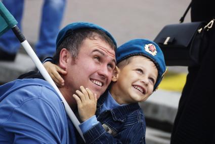 Отец-десантник с сыном наблюдают над высадкой парашютистов с самолета, перед шествием к мемориалу \"Черный тюльпан\" в Екатеринбурге.